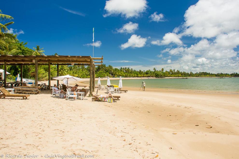 Imagem de pessoas tomando sol e ao fundo vegetaçao linda na Praia Ponta do Mutá.